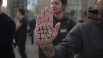 primer plano de la palma de la mano de un manifestante con el dibujo del símbolo de una jaula