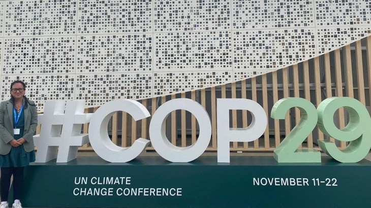 La responsable de Food Business al lado de un cartel que dice #Cop29